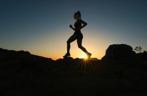 Silhouette of a woman running - either dawn or dusk.