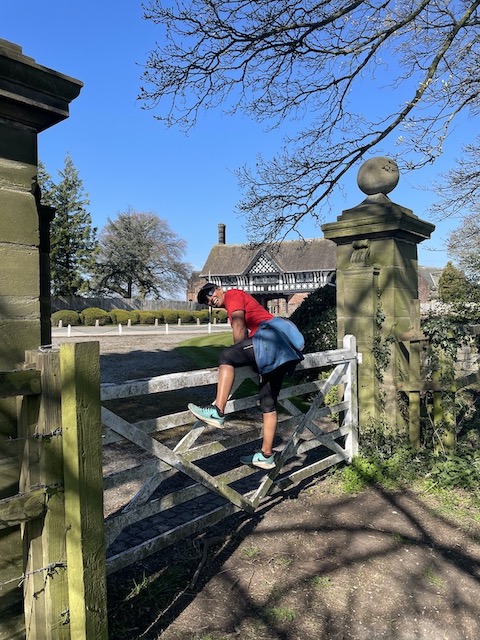 Me climbing over a fence