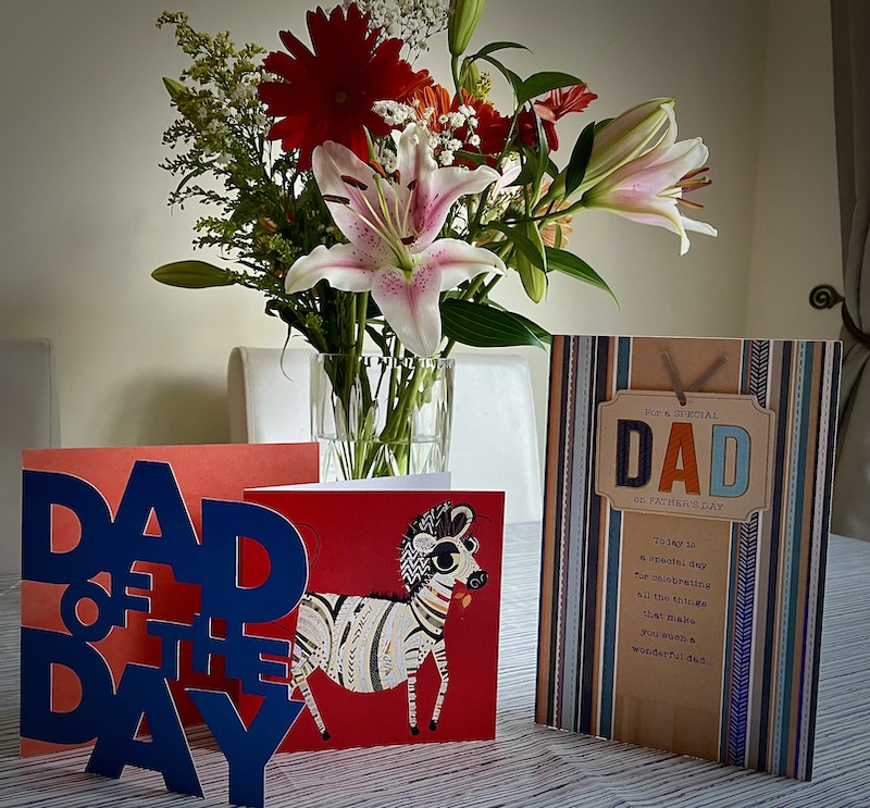 A bunch of flowers in a vase with Father's Day Cards