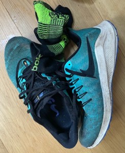 Muddy wet trainers and socks on the floor