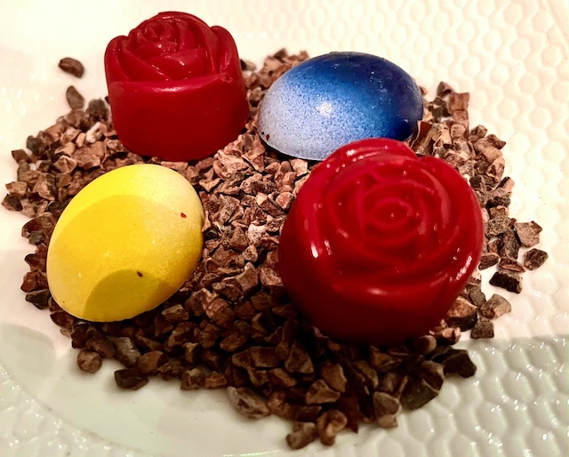 Handmade chocolates on a bed of cocoa nibs