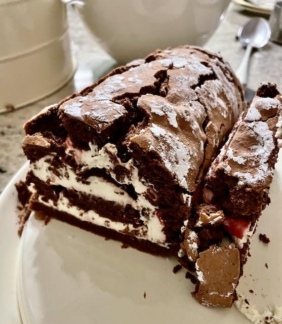 Middle section of a chocolate roulade with cream and jam.