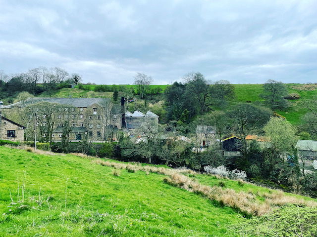 A view of part of the village across the river and the hills around it.