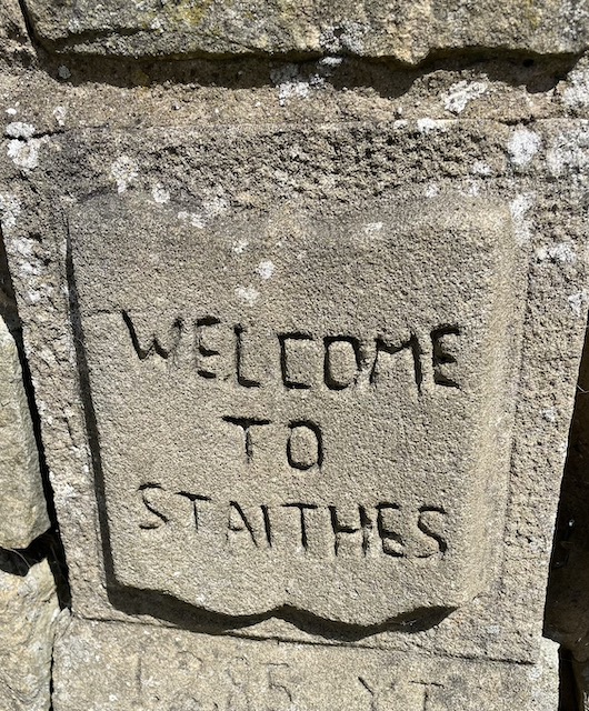 A stone sign saying 'Welcome to Staithes'