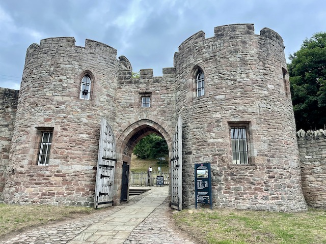 Beeston Castle entrance. Two round towers connected by a walkway and a door beneath.