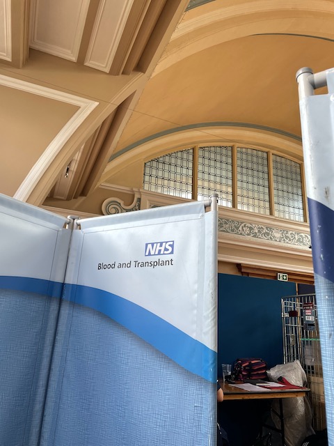 An NHS screen in the main hall of Hulme Hall, Port Sunlight