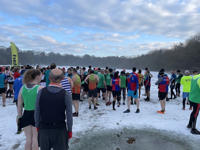 The runners lining up. Many in vests and shorts, and a few bobble hats