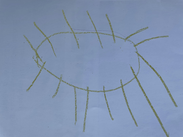 Child's yellow crayon drawing of the sun.