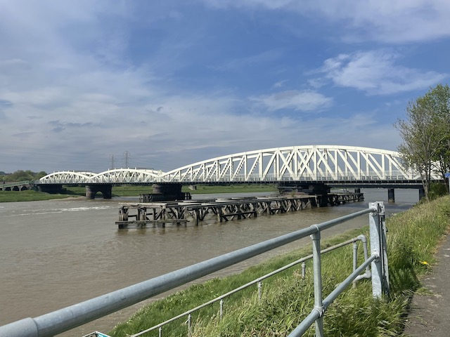 A big white bridge over the river Dee with blue skies above.