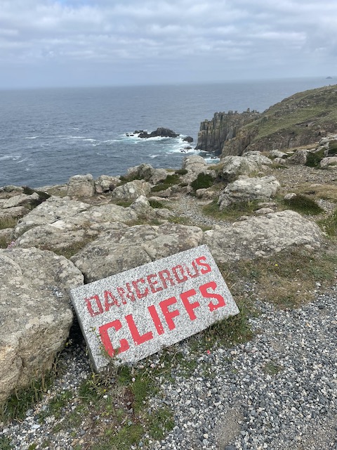 The cliff edge with a sign 'Dangerous Cliffs'