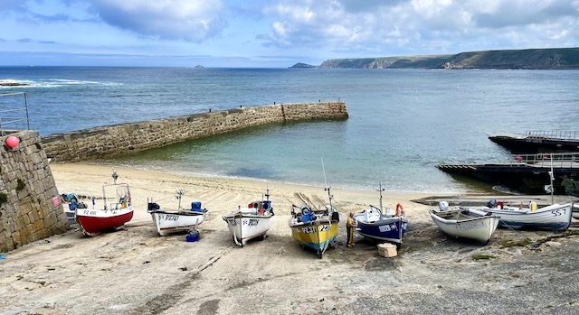 Fishing boats on the sand by the harbour wall