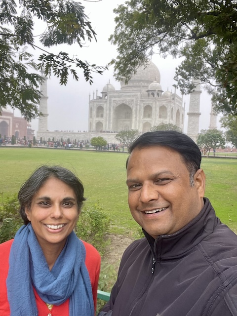 Taj Mahal in the background with me and Rocky in front of a grassy spot