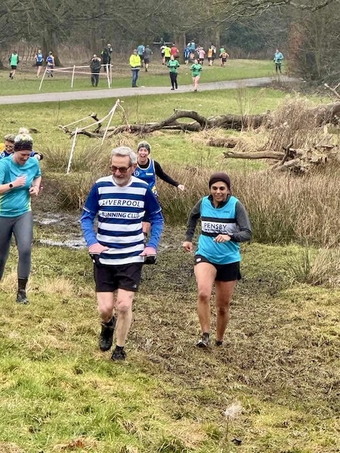 Stan on the front left and me on the right the muddy grass with lots of runners behind us.