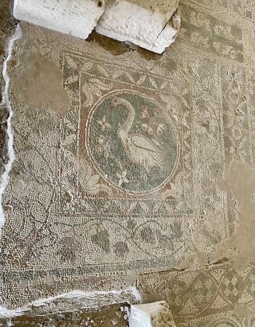 Damaged mosaic of a swan surrounded by floral and geometric borders