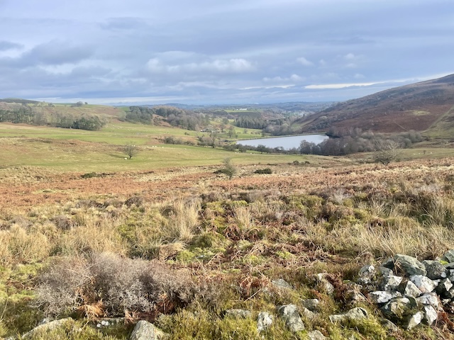 Landscape up the hills in Wales - a lake (reservoir?) in the distance.