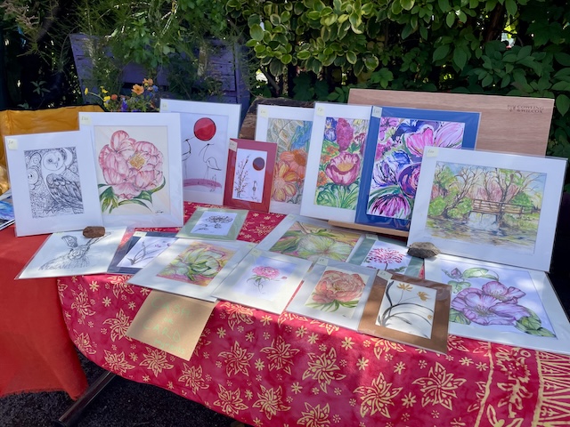 A table with lots of paintings arranged on it.