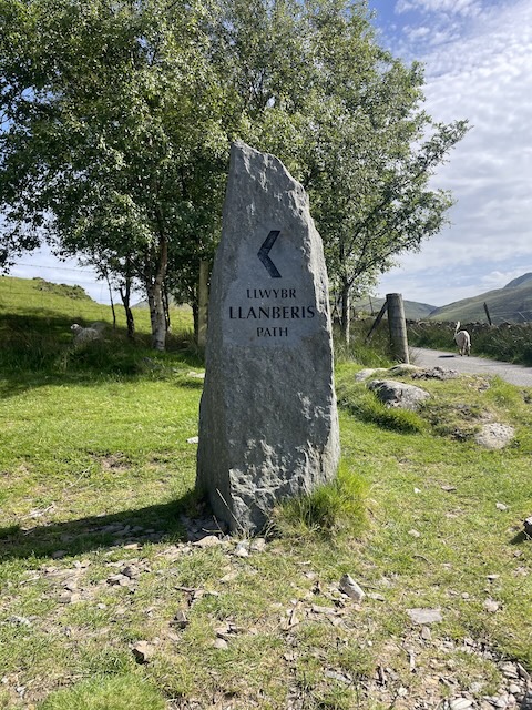 A sign showing an arrow with the Llanberis Path on a rough stone